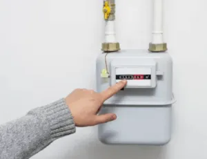 Foto di una mano che punta lo schermo digitale di un contatore del gas