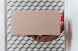 Primo piano di un pacco imballato sollevato da un braccio di un uomo