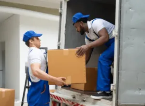 Due traslocatori che scaricano uno scatolone da un furgone da trasloco