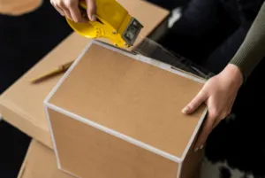 Primo piano di un pacco che viene accuratamente chiuso con del nastro trasparente