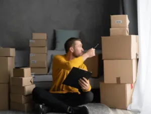 Ragazzo che controlla gli scatoli per il suo trasloco Ragazzo che controlla gli scatoli per il suo trasloco