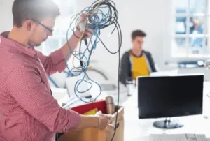 Ragazzo che ripone in una scatola diversi cavi elettronici Ragazzo che ripone in una scatola diversi cavi elettronici