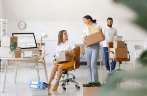 Due colleghe felici mentre si occupano di mettere a punto il trasloco azienda Due colleghe felici mentre si occupano di mettere a punto il trasloco azienda