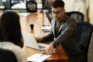 Ragazzo che discute con la sua collega della situazione del trasloco dell'ufficio