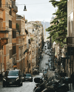 Una strada nel centro di Roma trafficata da macchine e scooter