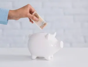 Persona che inserisce 5o euro in un salvadanaio