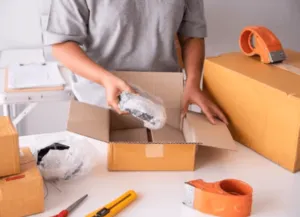 Ragazza che imballa un pacco da spedire con il materiale adatto