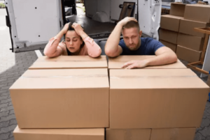 Una coppia che stanca si appoggia su una pila di scatoloni