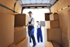 Due traslocatori che caricano degli scatoloni su un furgone per un trasloco