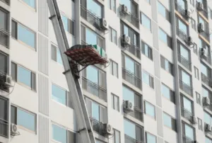 Scala idraulica con pedana aerea carica di oggetti che scende da un piano condominiale Scala idraulica con pedana aerea carica di oggetti che scende da un piano condominiale
