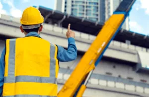Traslocatore con un casco protettivo e gilet ad alta visibilità mentre da le indicazioni per il posizionamento dell'autoscala