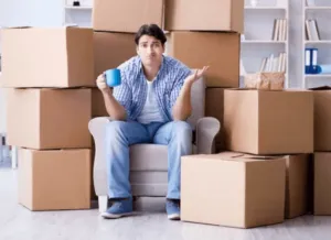 Ragazzo in difficoltà sommerso dagli scatoloni per trasloco Ragazzo in difficoltà sommerso dagli scatoloni per trasloco