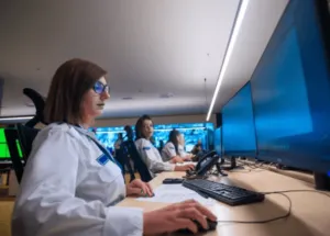 Signora che controlla le telecamere di sicurezza seduta alla sua scrivania