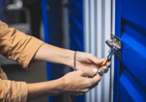 Ragazza che chiude il suo self storage con il lucchetto