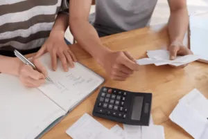 Due persone che fanno i conti con l'aiuto della calcolatrice