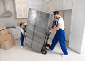 Due traslocatori che trasportano un frigorifero imballato per il trasloco di una cucina