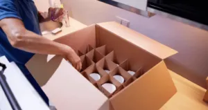 Traslocatore che ripone i bicchieri in apposita scatole per imballaggio Traslocatore che ripone i bicchieri in apposita scatole per imballaggio