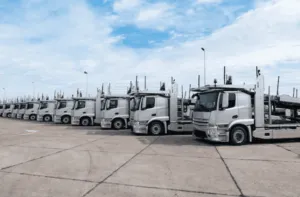 Foto di una lunga fila di camion con bisarca parcheggiati
