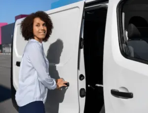 Una giovane donna mentre apre lo sportello laterale di un furgone per trasloco Una giovane donna mentre apre lo sportello laterale di un furgone per trasloco