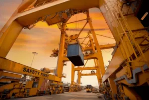 Una gru che solleva un container pronto per la spedizione via mare Una gru che solleva un container pronto per la spedizione via mare