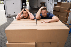 Una coppia esausta appoggiata su diversi scatoloni