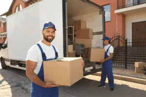 Due traslocatori mentre caricano le scatole sul furgone Due traslocatori mentre caricano le scatole sul furgone