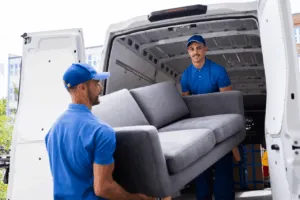 Due traslocatori che caricano sul furgone un divano Due traslocatori che caricano sul furgone un divano